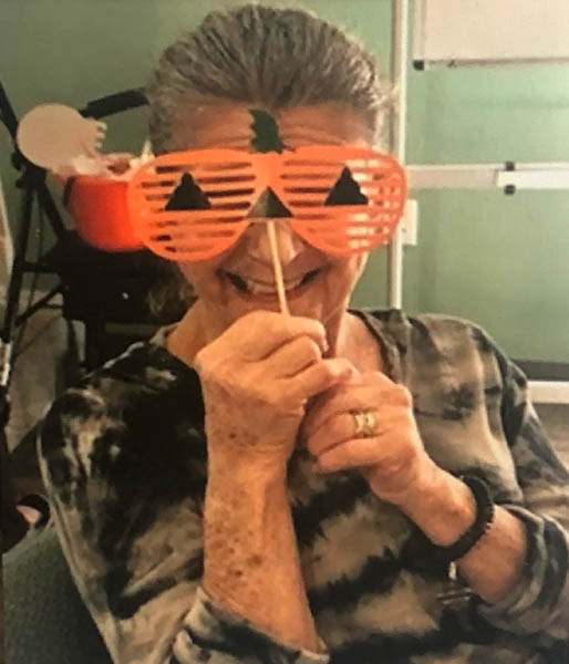 assisted living resident Judy with pumpkin mask