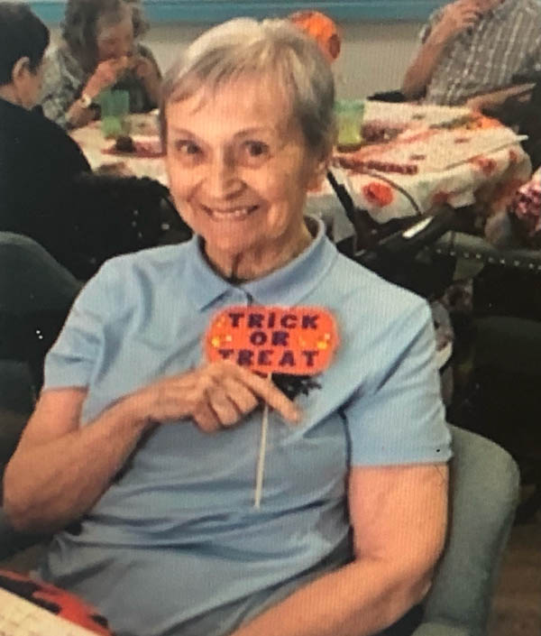 assisted living resident Pat with trick or treat sign