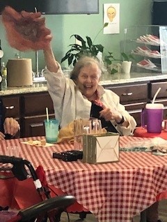 assisted living resident waving her hat