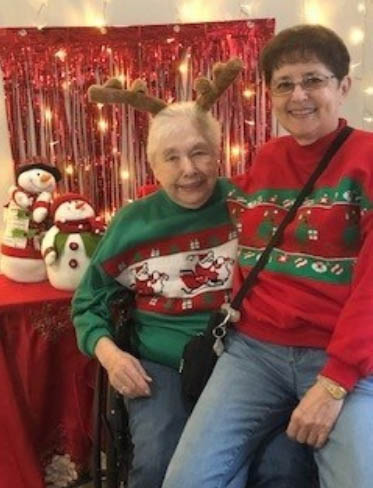 assisted living resident wearing reindeer antlers smiling